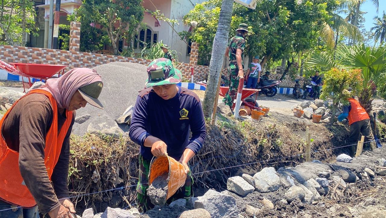 Pratu Firman bersama anggota lainnya terus mempercepat proses pengerjaan pembuatan drainase di Desa Lebakharjo, Kecamatan Ampelgading, Kabupaten Malang.