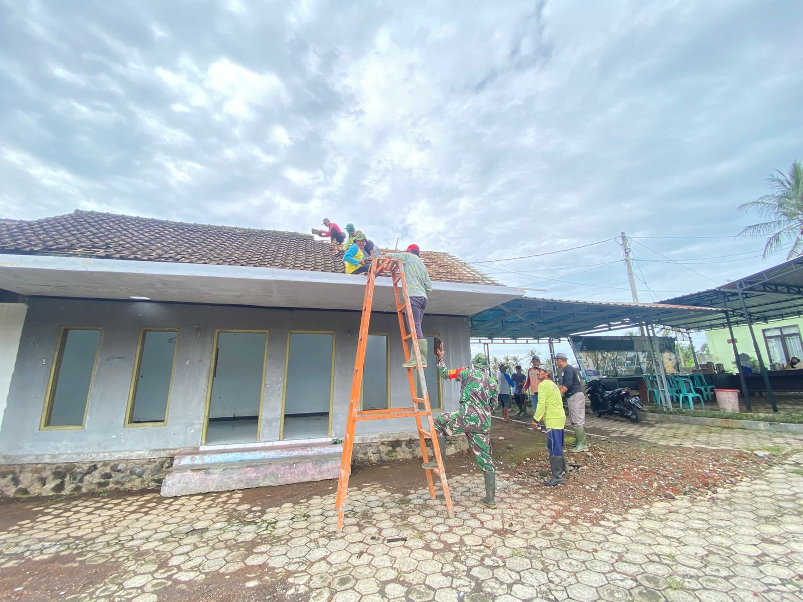 Semangat Gotong Royong! Babinsa Glenmore Dampingi Pembongkaran Atap Kantor BPD Bumiharjo